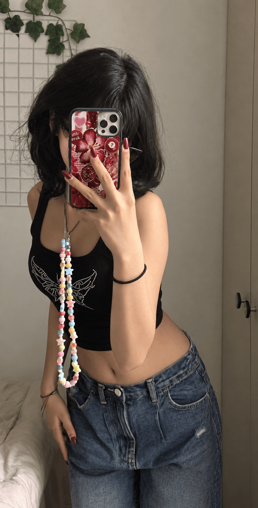 Mirror selfie featuring a burgundy red cherry and heart collage phone case.